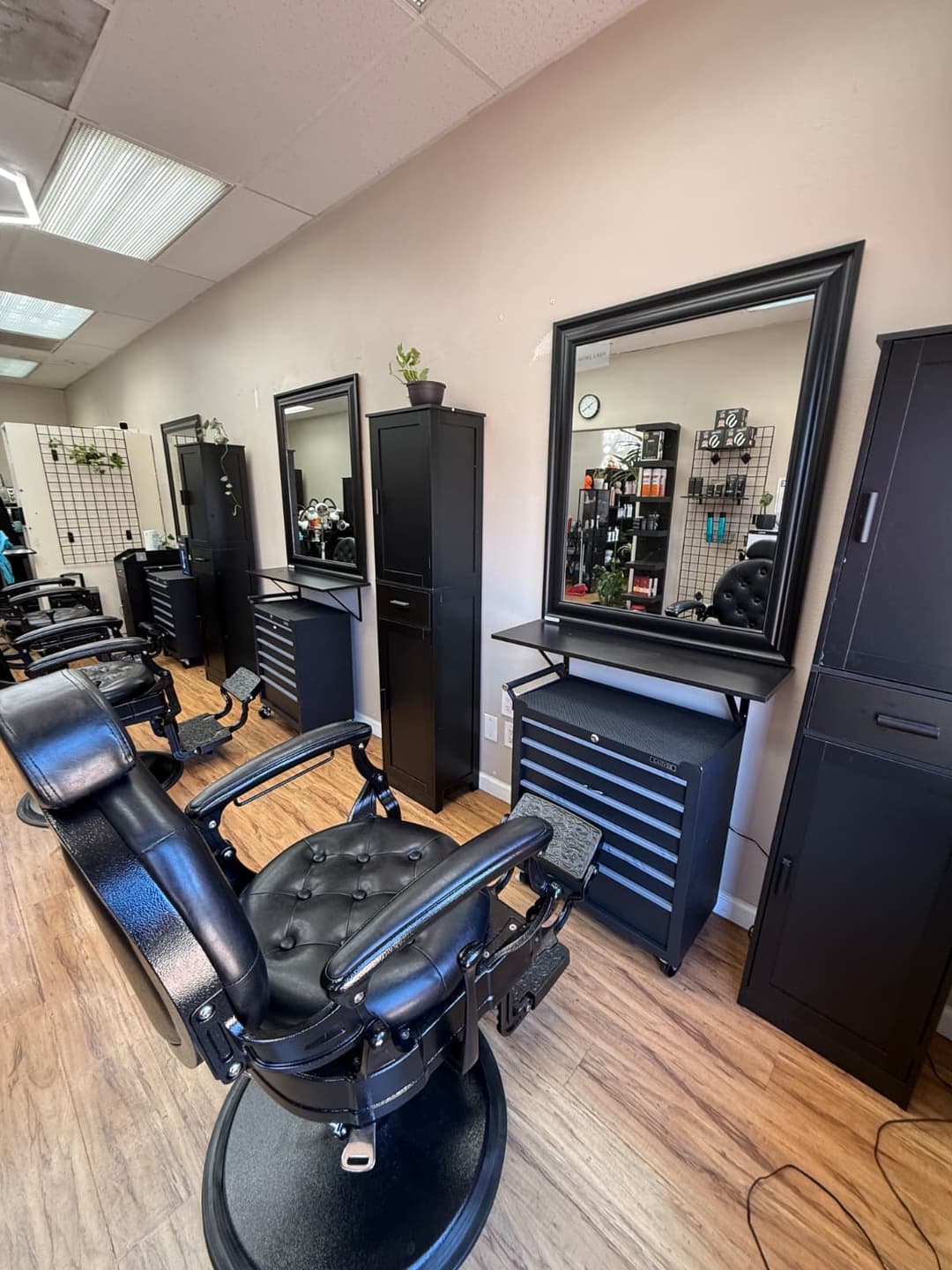 Black reclining barber chair and mirror station inside Zion Salon & Barber Shop in National City, California.